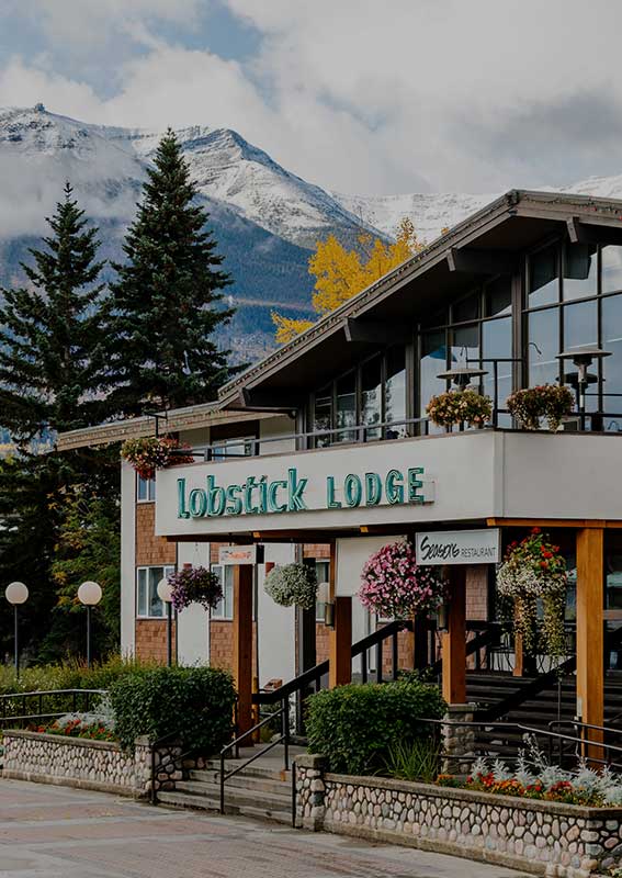 The Lobstick Lodge set with a mountain rising in the background.